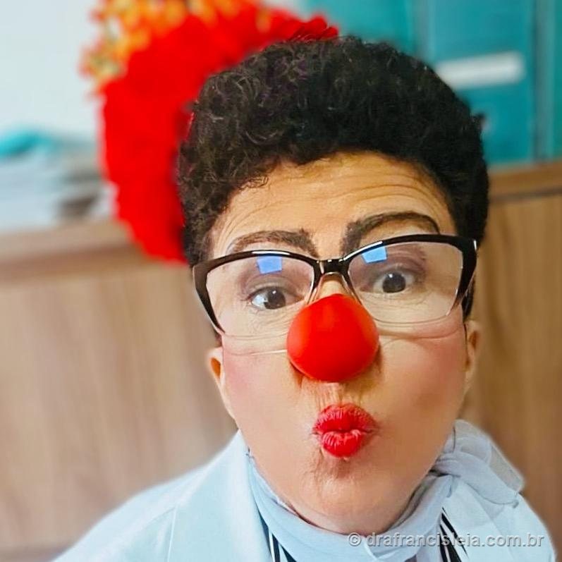Dra. Francisléia em selfie divertida, mandando um beijo, com nariz de palhaço vermelho